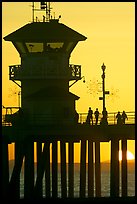People and pier silhouetted by the setting sun. Huntington Beach, Orange County, California, USA ( color)