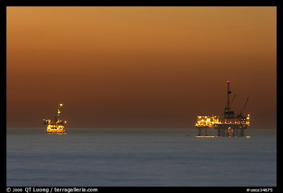 Oil drilling platforms lighted at dusk. Huntington Beach, Orange County, California, USA