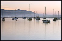 Yachts reflected in calm  Morro Bay harbor, sunset. Morro Bay, USA