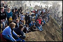 Spectators sitting on cliff to see mavericks contest. Half Moon Bay, California, USA (color)