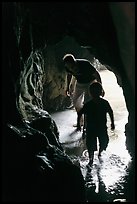 Boy and man exploring sea cave. Bandon, Oregon, USA (color)
