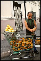 A man peels oranges to make an orange drink, which is drunk from the fruit itself, Ponce. Puerto Rico ( color)