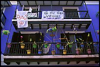 Facade of house painted in blue with pots, balconies and anti-war signs. San Juan, Puerto Rico