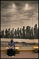African American man sitting in front of march mural inside Martin Luther King, Jr. Visitor Center. Atlanta, Georgia, USA (color)
