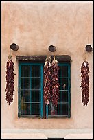 Ristras hanging from vigas and blue window. Taos, New Mexico, USA ( color)