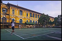 Men play tennis in front of colonial-area courthouse. Ho Chi Minh City, Vietnam (color)