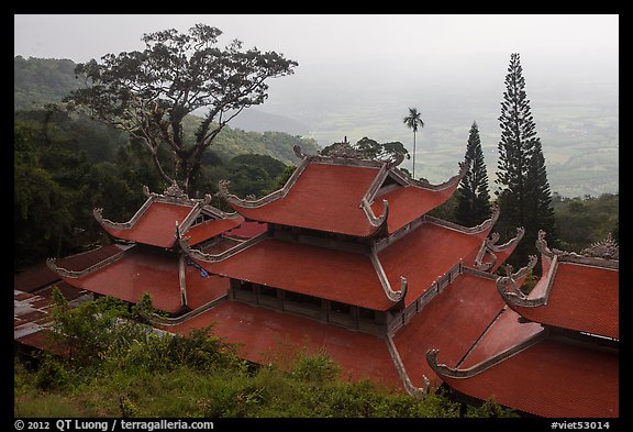 Temple rooftop overlooking plains in mist. Ta Cu Mountain, Vietnam