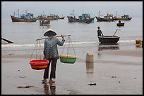 Woman with yoke baskets on beach. Mui Ne, Vietnam ( color)