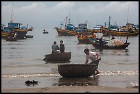 Fishermen on roundboats and fishing fleet. Mui Ne, Vietnam ( color)