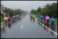 Riders wearing colorful ponchos on wet road on Hwy 1 south of Hue. Vietnam ( color)