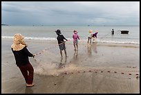Fishermen lining up to pull net onto beach. Mui Ne, Vietnam ( color)