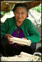 Woman selling sweet rice cooked in bamboo tubes. Vietnam (color)
