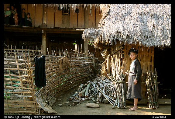 Woman in front of her hut and family on stilt house, between Lai Chau and Tam Duong. Northwest Vietnam (color)
