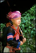 Hmong girl sheltering herself and her younger sibling with an unbrella, between Lai Chau and Tam Duong. Northwest Vietnam (color)