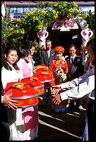 Gifts are exchanged as a newly wedded couple exits the bride's home. Ho Chi Minh City, Vietnam (color)