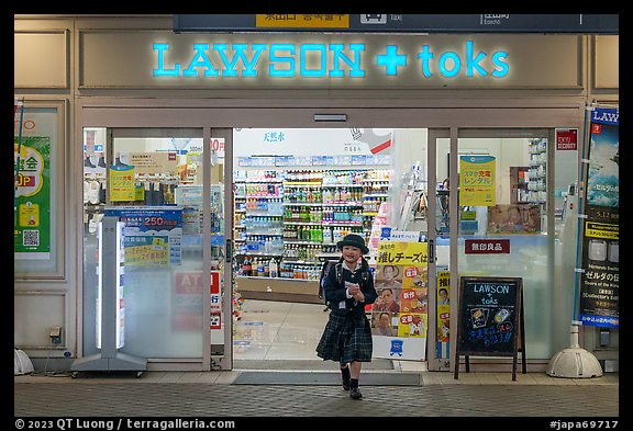 Girl in school uniform walking out of convenience store. Tokyo, Japan (color)