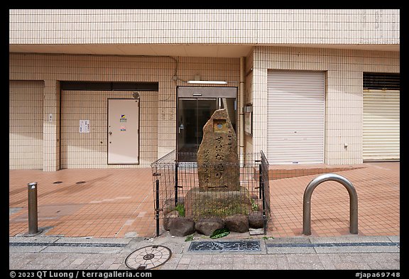 Stone monument on modern street. Fujisawa, Japan (color)