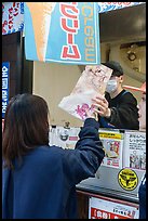 Customer receiving tako senbei octopus cracker. Enoshima Island, Japan ( color)