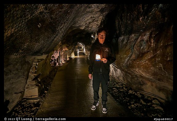 Boy with candle in first Enoshima Iwaya Cave. Enoshima Island, Japan (color)