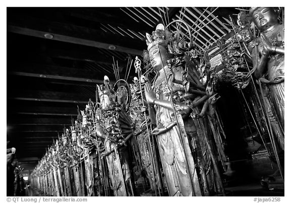 Rows of statues of the thousand-armed Kannon (buddhist goddess of mercy), Sanjusangen-do Temple. Kyoto, Japan (black and white)