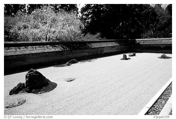 Ryoan-ji Temple has on of the most famous Zen gardens in the karesansui (dry landscape) style, a collection of 15 rocks in a sea of raked sand, enclosed by an earthen wall. Kyoto, Japan (black and white)