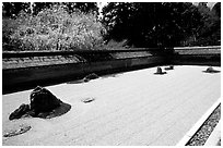 Ryoan-ji Temple has on of the most famous Zen gardens in the karesansui (dry landscape) style, a collection of 15 rocks in a sea of raked sand, enclosed by an earthen wall. Kyoto, Japan ( black and white)