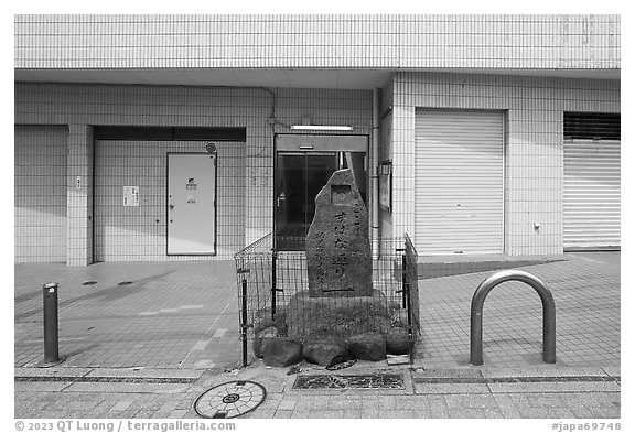Stone monument on modern street. Fujisawa, Japan (black and white)