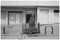 Stone monument on modern street. Fujisawa, Japan ( black and white)