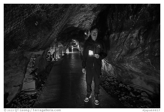 Boy with candle in first Enoshima Iwaya Cave. Enoshima Island, Japan (black and white)