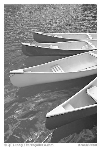 Close up of red, yellow and blue canoes, Moraine Lake. Banff National Park, Canadian Rockies, Alberta, Canada (black and white)