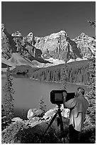 Photographer operating a 8x10 view camera at Moraine Lake. Banff National Park, Canadian Rockies, Alberta, Canada (black and white)