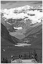 Tourists at observation platform, looking at  Lake Louise and  Victoria Peak. Banff National Park, Canadian Rockies, Alberta, Canada (black and white)