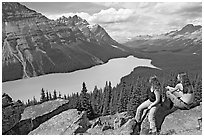 Tourists sitting on a rook overlooking Peyto Lake. Banff National Park, Canadian Rockies, Alberta, Canada (black and white)