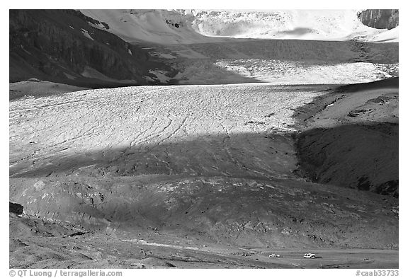 Base of Athabasca Glacier with cars parked on lot. Jasper National Park, Canadian Rockies, Alberta, Canada (black and white)