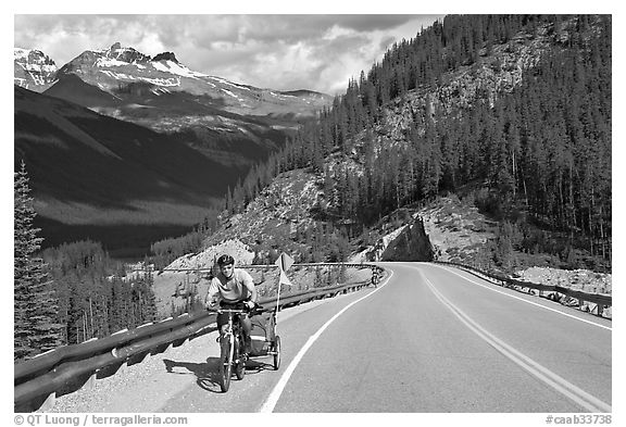 Cyclist with tow, Icefieds Parkway. Jasper National Park, Canadian Rockies, Alberta, Canada (black and white)