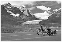 Cyclists on the Icefields Parkway in front of the Athabasca Glacier. Jasper National Park, Canadian Rockies, Alberta, Canada (black and white)