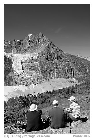 Hikers sitting in front of Mt Edith Cavell next to trail. Jasper National Park, Canadian Rockies, Alberta, Canada (black and white)