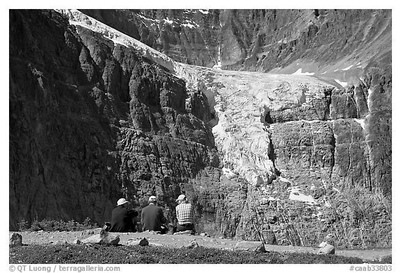Hikers looking at a hanging glacier on  Mt Edith Cavell. Jasper National Park, Canadian Rockies, Alberta, Canada (black and white)