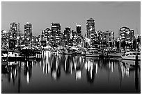 Fishing boats and skyline light reflected at night. Vancouver, British Columbia, Canada (black and white)