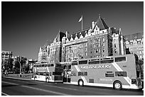 Red double-decker tour busses in front of Empress hotel. Victoria, British Columbia, Canada ( black and white)