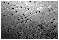 Pebbles and wet sand at sunset, Half-moon bay. Pacific Rim National Park, Vancouver Island, British Columbia, Canada ( black and white)