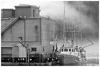 Commercial fishing boat next to a fishery, Tofino. Vancouver Island, British Columbia, Canada ( black and white)