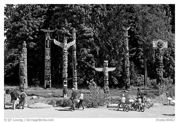 Tourists loooking at Totems, Stanley Park. Vancouver, British Columbia, Canada (black and white)