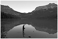 Woman fishing in Emerald Lake, sunset. Yoho National Park, Canadian Rockies, British Columbia, Canada ( black and white)