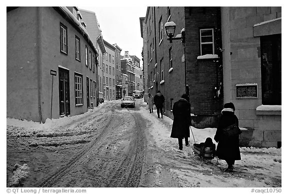 Residents pulling a sled with a child in a street, Quebec City. Quebec, Canada