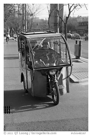 Enclosed three wheel motorcycle on street. Beijing, China (black and white)