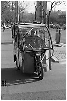 Enclosed three wheel motorcycle on street. Beijing, China ( black and white)