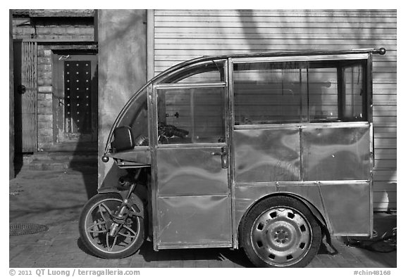 Enclosed scooter on sidewalk. Beijing, China (black and white)