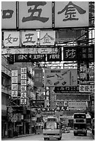 Busses in a street filled up with signs in Chinese, Kowloon. Hong-Kong, China ( black and white)