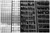 Glass building next to older buildings with air conditioners, Hong-Kong Island. Hong-Kong, China ( black and white)
